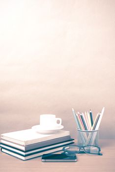 coffee,phone,eyeglasses,stack of book and color pencil on wood table background vintage style