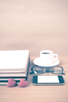 coffee,phone,eyeglasses,stack of book and heart on wood table background vintage style