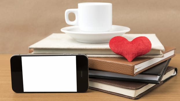 coffee,phone,stack of book and heart on wood table background