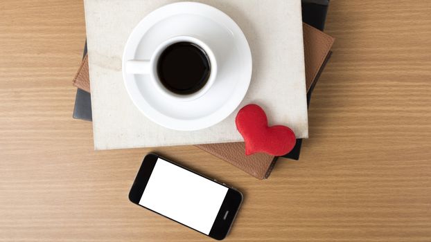 coffee,phone,stack of book and heart on wood table background