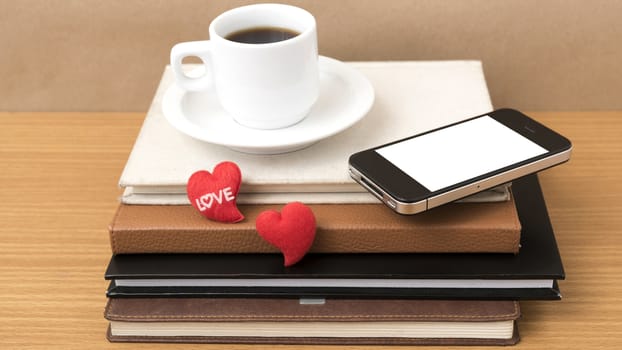 coffee,phone,stack of book and heart on wood table background