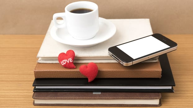 coffee,phone,stack of book and heart on wood table background