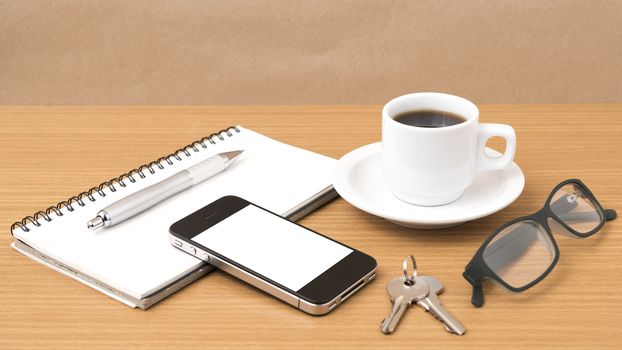 coffee,phone,notepad,eyeglasses and key on wood table background