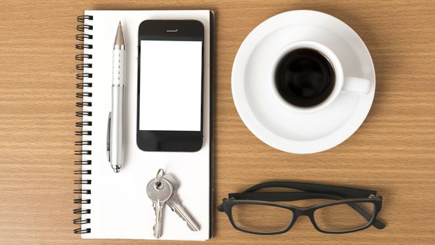 coffee,phone,notepad,eyeglasses and key on wood table background