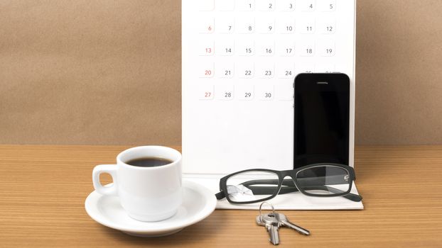 coffee,phone,eyeglasses,calendar and key on wood table background