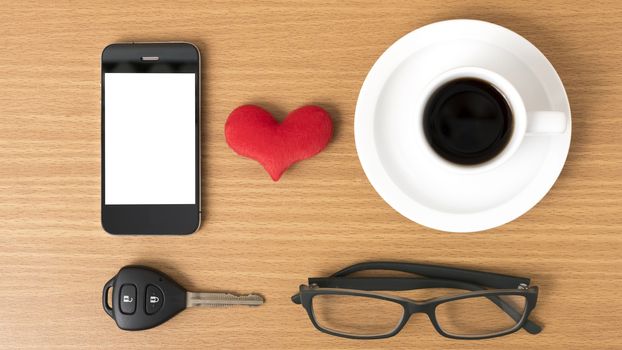 coffee,phone,eyeglasses and car key on wood table background