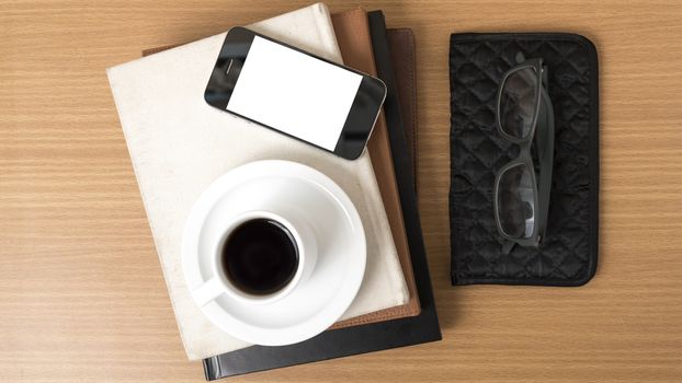 coffee,phone,eyeglasses,stack of book and wallet on wood table background