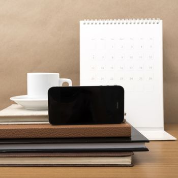 coffee,phone,stack of book and calendar on wood table background