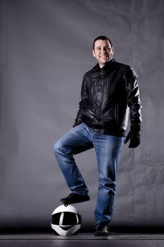 motorist with a helmet, leather jacket and jeans, on grunge background with harsh lighting