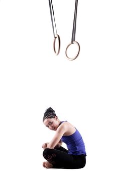 fit girl girl exercising on gymnast rings, against white background