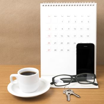 coffee,phone,eyeglasses,calendar and key on wood table background