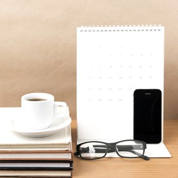 coffee,phone,eyeglasses,stack of book and calendar on wood table background