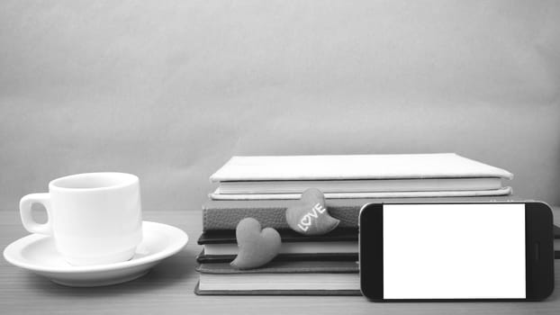 coffee,phone,stack of book and heart on wood table background black and white color