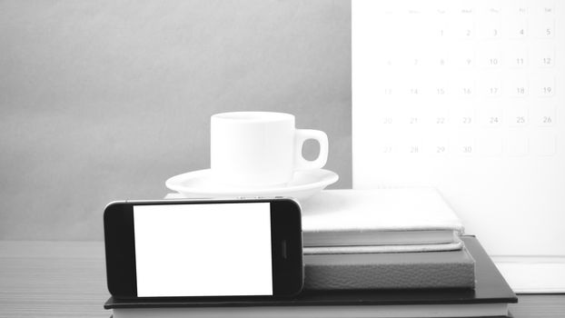 coffee,phone,stack of book and calendar on wood table background black and white color