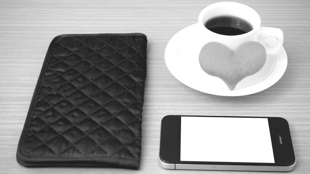 coffee,phone,wallet and heart on wood table background black and white color