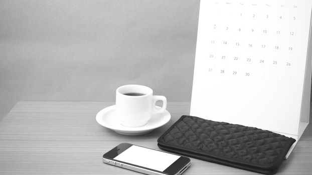 coffee,phone,wallet and canlendar on wood table background black and white color