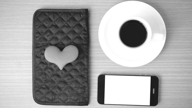 coffee,phone,wallet and heart on wood table background black and white color