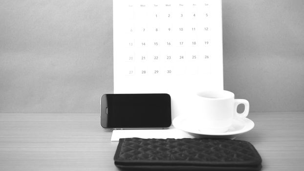 coffee,phone,wallet and canlendar on wood table background black and white color