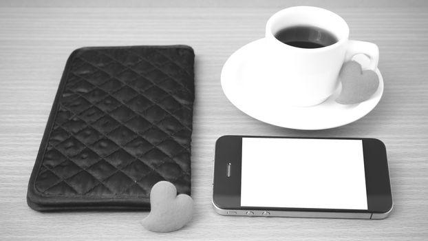 coffee,phone,wallet and heart on wood table background black and white color