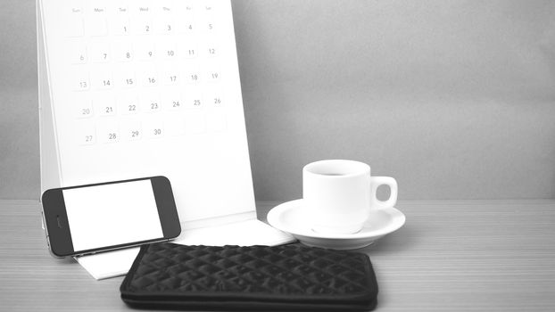 coffee,phone,wallet and canlendar on wood table background black and white color