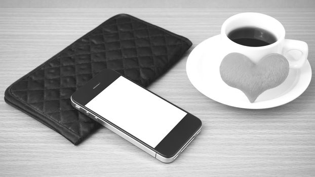 coffee,phone,wallet and heart on wood table background black and white color