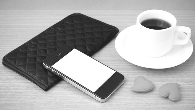 coffee,phone,wallet and heart on wood table background black and white color