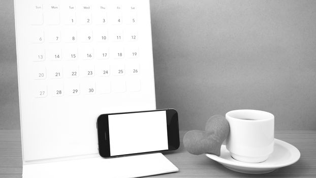 coffee,phone,calendar and heart on wood table background black and white color