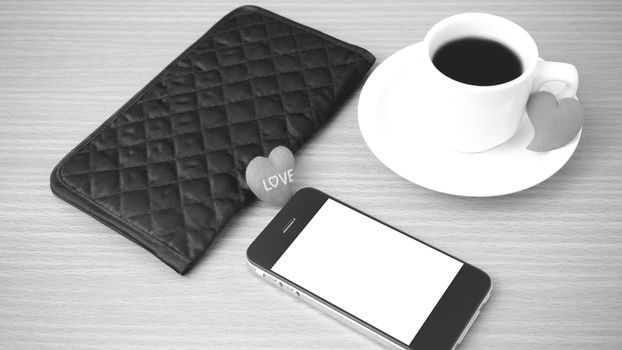 coffee,phone,wallet and heart on wood table background black and white color