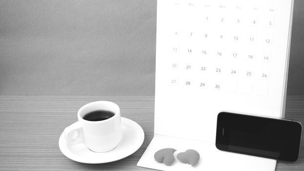 coffee,phone,calendar and heart on wood table background black and white color