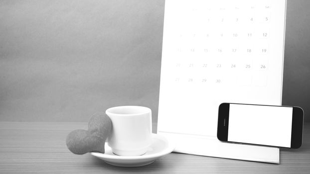 coffee,phone,calendar and heart on wood table background black and white color