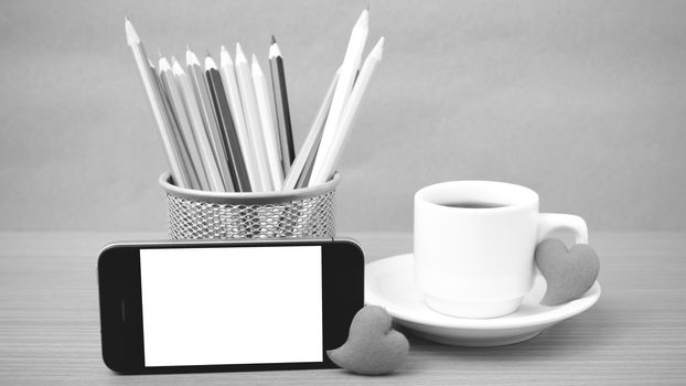 coffee,phone,color pencil and heart on wood table background black and white color