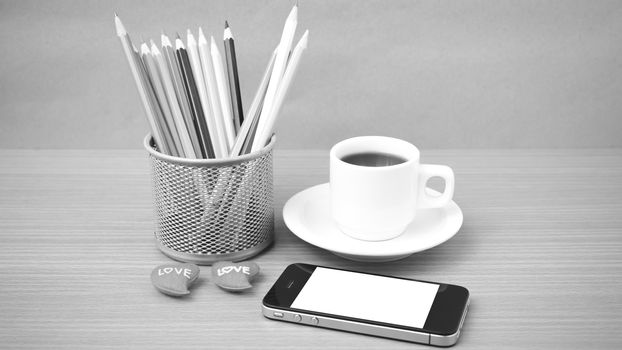 coffee,phone,color pencil and heart on wood table background black and white color