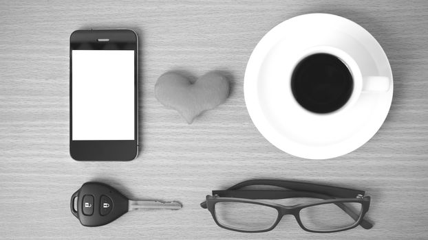 coffee,phone,eyeglasses and car key on wood table background black and white color