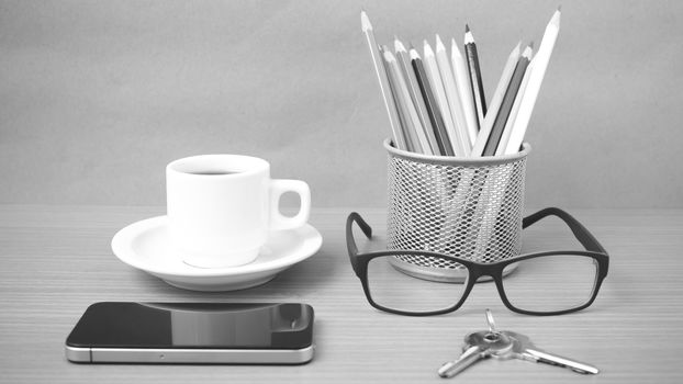 coffee,phone,eyeglasses,color pencil and key on wood table background black and white color