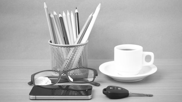 coffee,phone,eyeglasses,color pencil and car key on wood table background black and white color