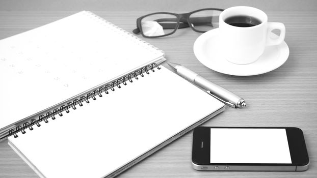 coffee,phone,eyeglasses,notepad and canlendar on wood table background black and white color