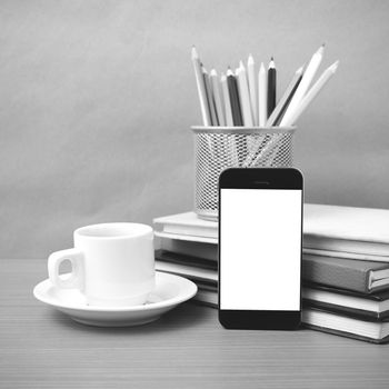 coffee,phone,stack of book and color pencil on wood table background black and white color