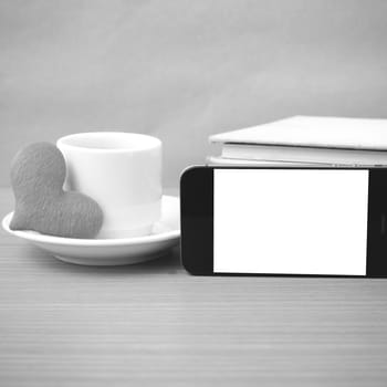 coffee,phone,stack of book and heart on wood table background black and white color