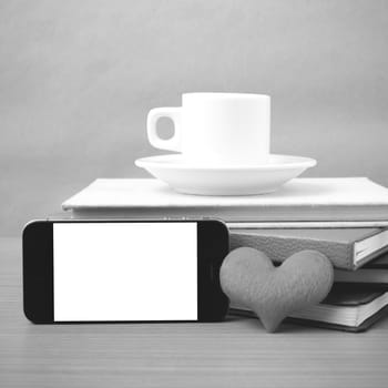 coffee,phone,stack of book and heart on wood table background black and white color