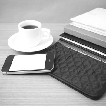 coffee,phone,stack of book and wallet on wood table background black and white color