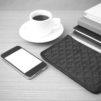 coffee,phone,stack of book and wallet on wood table background black and white color