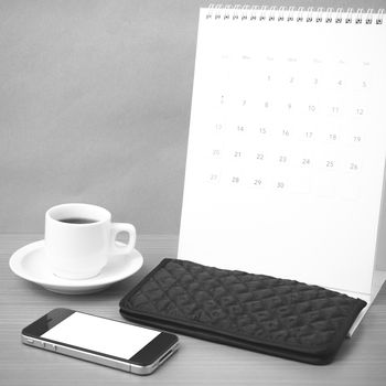 coffee,phone,wallet and canlendar on wood table background black and white color