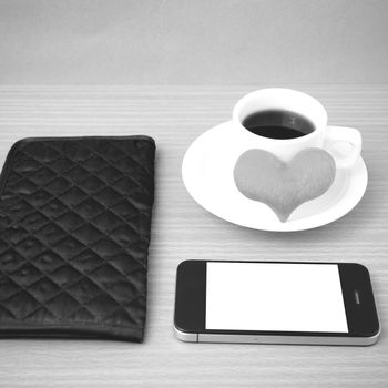 coffee,phone,wallet and heart on wood table background black and white color