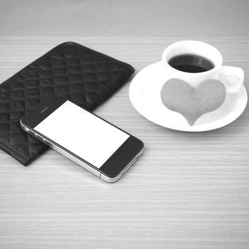 coffee,phone,wallet and heart on wood table background black and white color