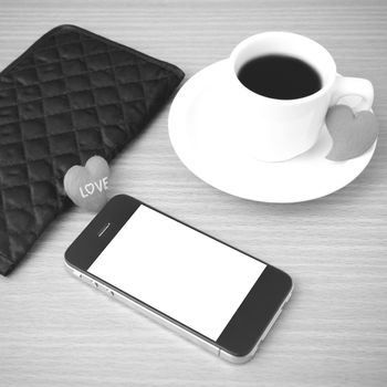 coffee,phone,wallet and heart on wood table background black and white color