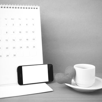 coffee,phone,calendar and heart on wood table background black and white color