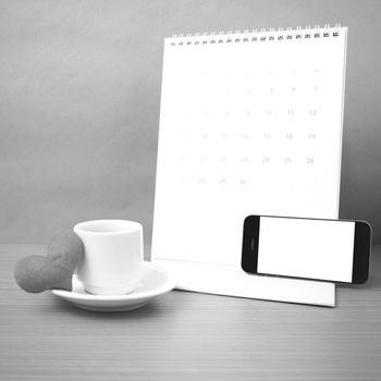 coffee,phone,calendar and heart on wood table background black and white color