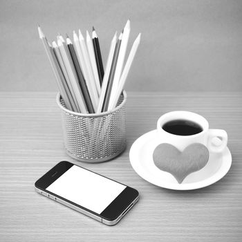 coffee,phone,color pencil and heart on wood table background black and white color