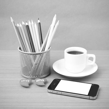 coffee,phone,color pencil and heart on wood table background black and white color