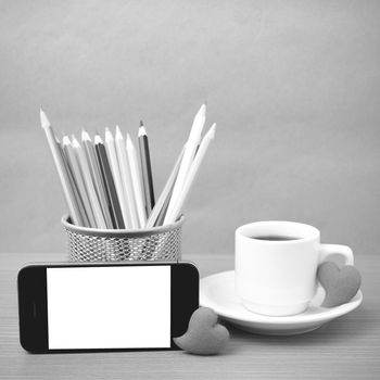 coffee,phone,color pencil and heart on wood table background black and white color